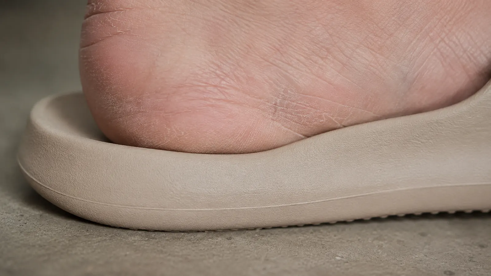 Close-up of the OOfoam footbed compression under a heel, showing arch contact area